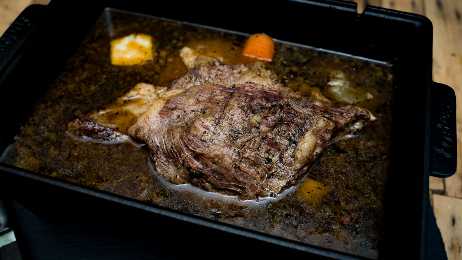 Suppenfleisch aus der Brust vom Oberpfalz Rind auf einem Holzbrett, mariniert und mit frischen Kräutern garniert, ideales Fleisch für aromatische Suppen und Eintöpfe.