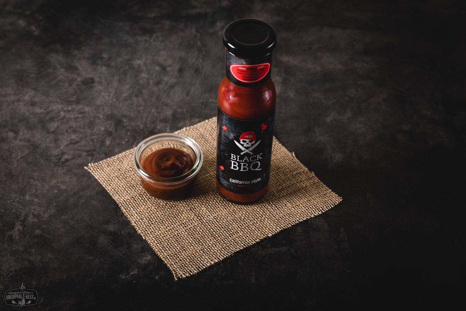 Black BBQ Leo's Ketchup Flasche vor weißem Hintergrund mit Etikett in Schwarz und Rot, leckerer Tomatenketchup für Grill und BBQ.