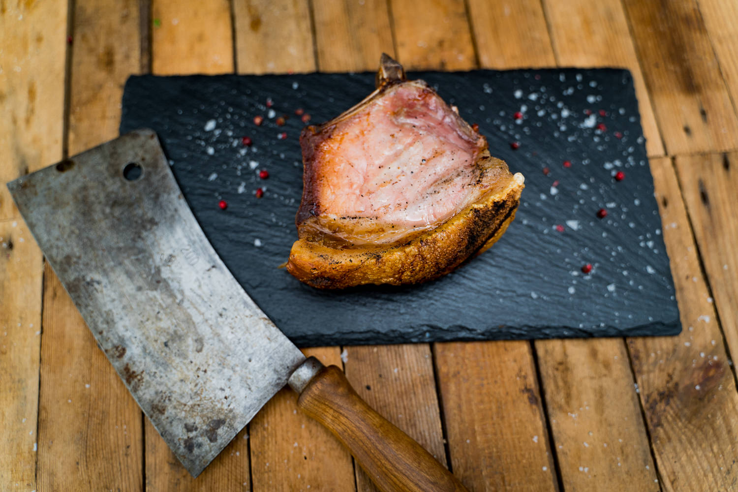 Kotelett-Steak Dry Aged vom Oberpfälzer Landschwein auf Holzbrett – hochwertiges Fleisch mit idealer Marmorierung und intensiver Farbe, perfekt für Grill oder Pfanne, präsentiert auf rustikaler Unterlage.