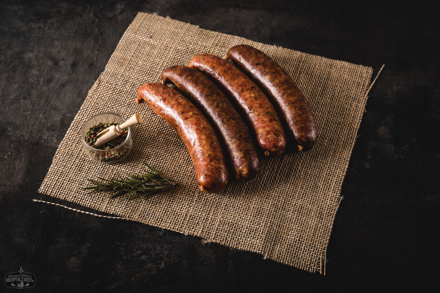 4 Mettenwürste auf schwarzem Hintergrund, traditionelle deutsche Wurstspezialität, Oberpfalz Beef, perfekte Delikatesse für deftige Brotzeiten und bayerische Küche.