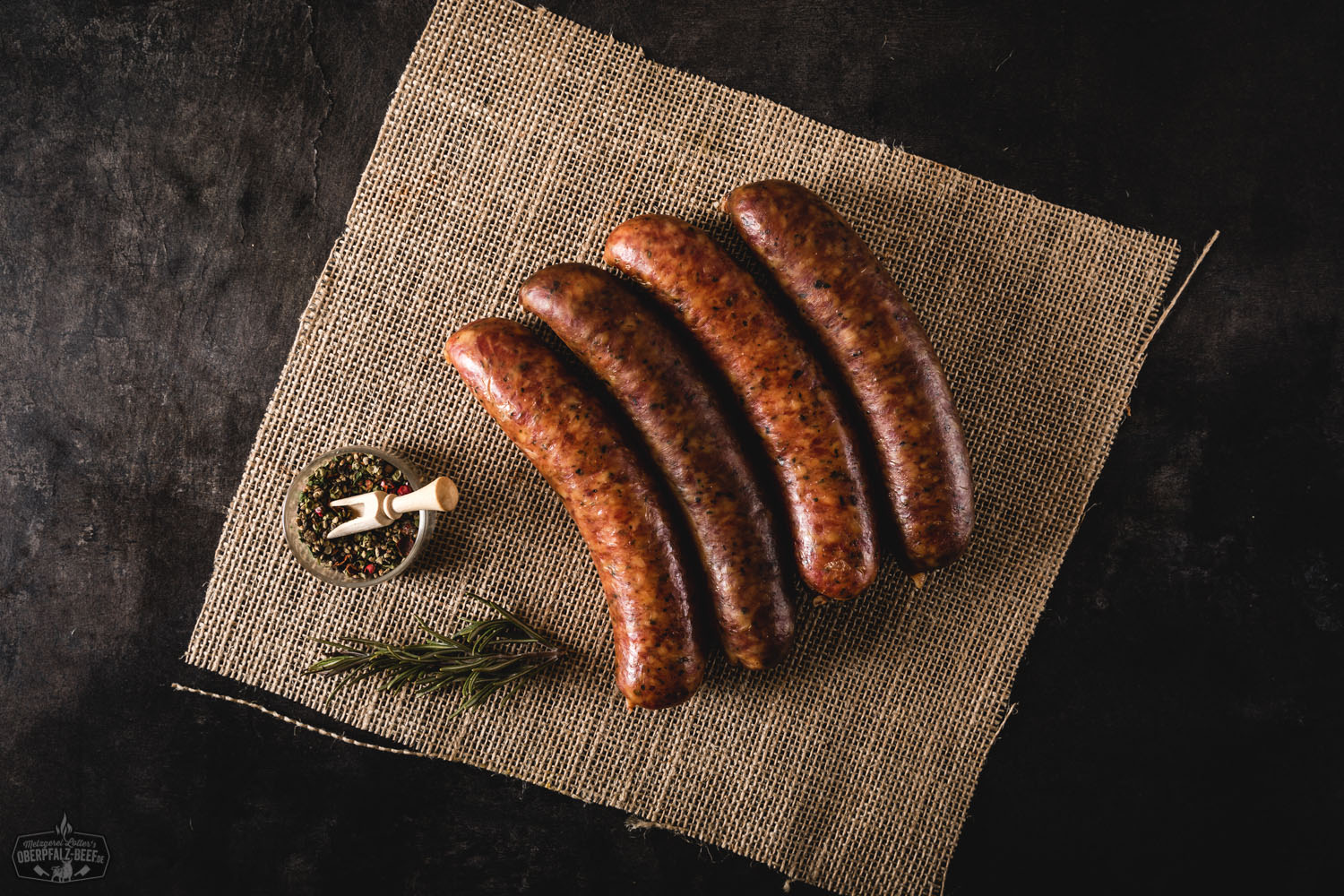 4 Mettenwürste auf schwarzem Hintergrund, traditionelle deutsche Wurstspezialität, Oberpfalz Beef, perfekte Delikatesse für deftige Brotzeiten und bayerische Küche.