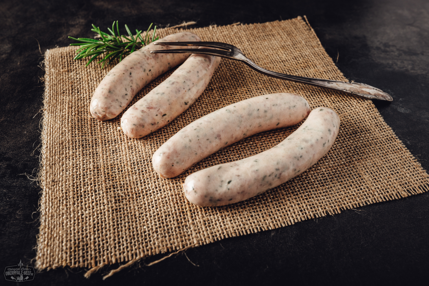 Ein Teller mit frisch gegrillten Bärlauchbratwürsten, angerichtet mit einer Beilage von frischen Kräutern. Perfekt für den Grillabend - das Besondere Highlight aus der Oberpfalz.