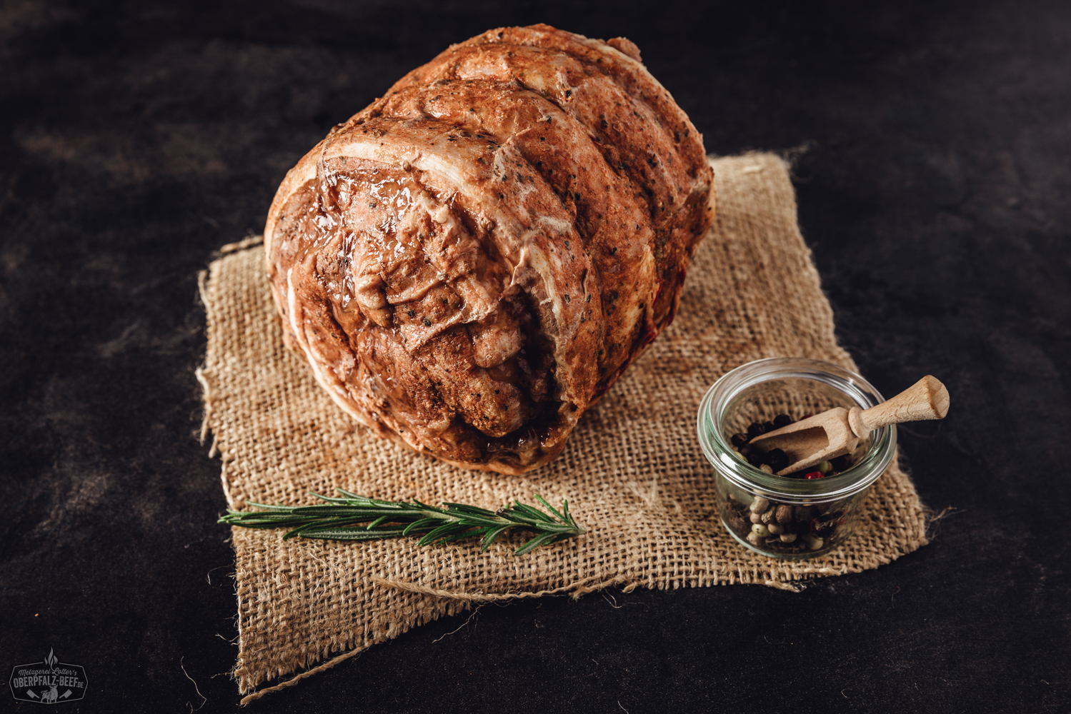 Sous-vide vorgegarter Rollbraten vom Kalb in vakuumverpackter Aufmachung auf einem Holztisch, zart und saftig, perfekt für feine Gourmet-Gerichte.