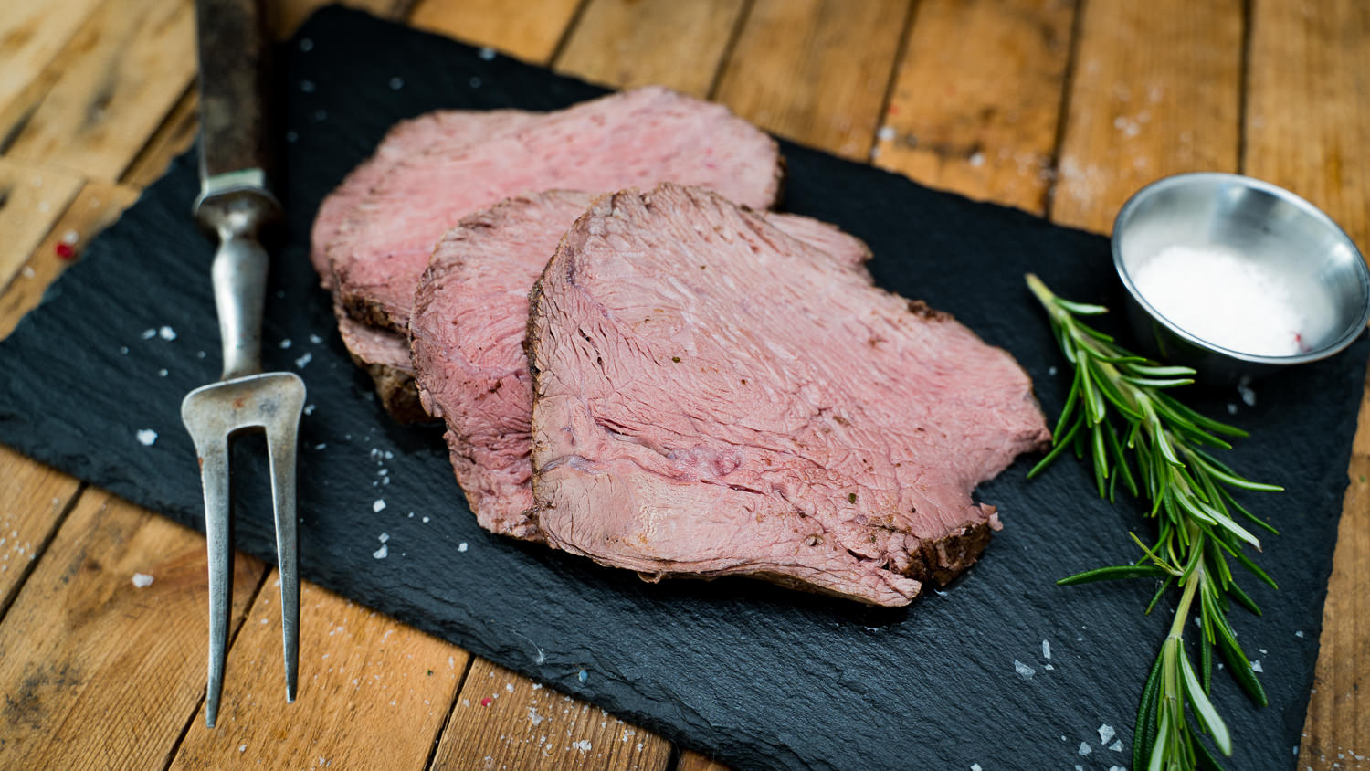 Sauerbraten eingelegt in Marinade mit Gewürzen und Gemüse auf einem Holztisch, Oberpfalz Beef - Traditionelles deutsches Gericht perfekt zum Schmoren und Genießen.