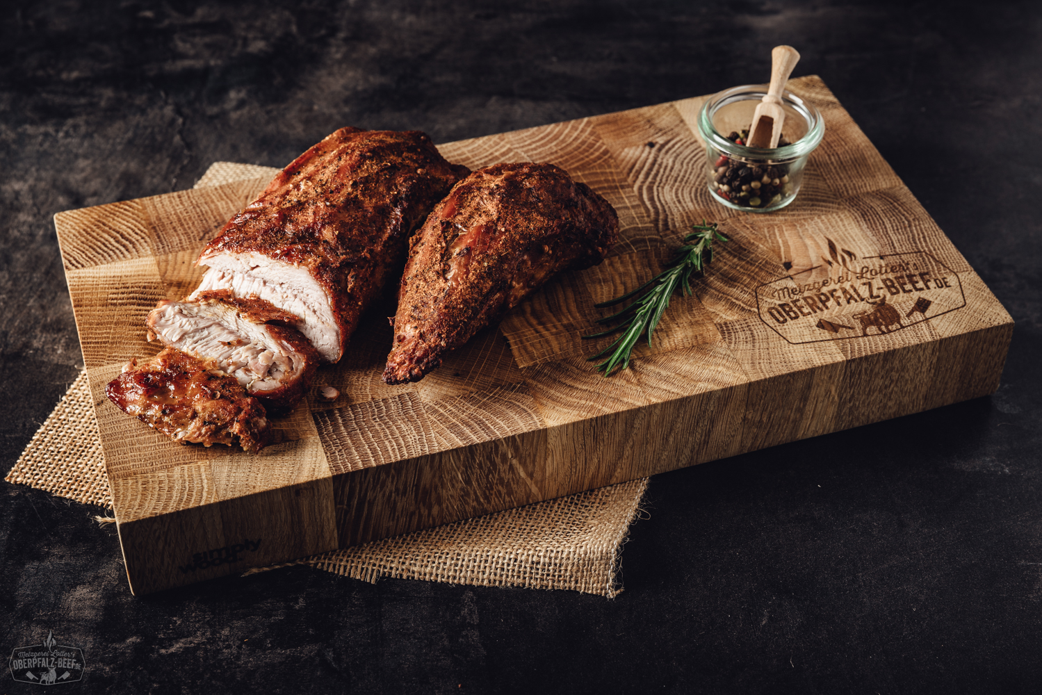 Sous-vide vorgegarter Kalbsbraten aus der Schulter auf einem Holzbrett platziert, saftig und zart, perfekt gegart mit goldener Kruste, präsentiert in einem rustikalen Ambiente mit frischen Kräutern.