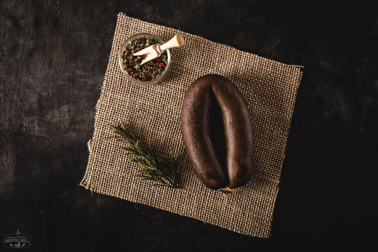 Ein geräucherter Oberpfälzer Leberwurst-Ring aus qualitativ hochwertigem Oberpfalz-Beef, präsentiert auf einer neutralen Oberfläche, perfektioniert für den authentischen Geschmack traditioneller bayerischer Wurstwaren.