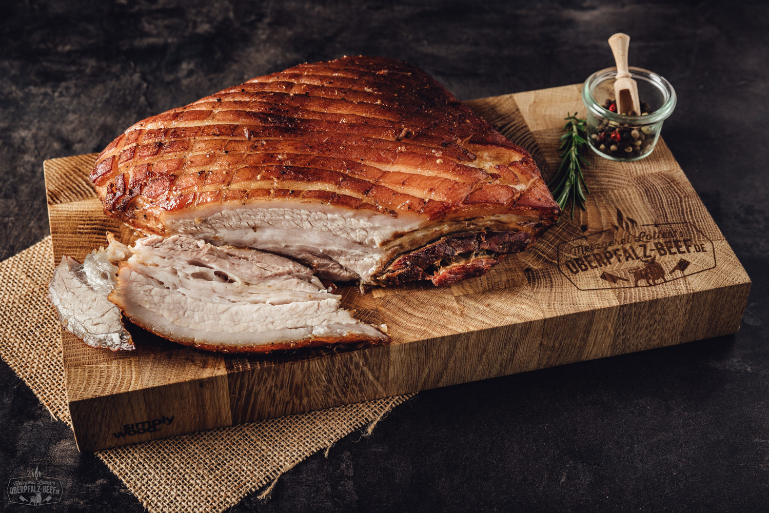 Ein köstlicher, sous vide vorgegarter Krustenbraten vom Schweinebauch mit knuspriger Kruste auf einem rustikalen Holzbrett präsentiert.