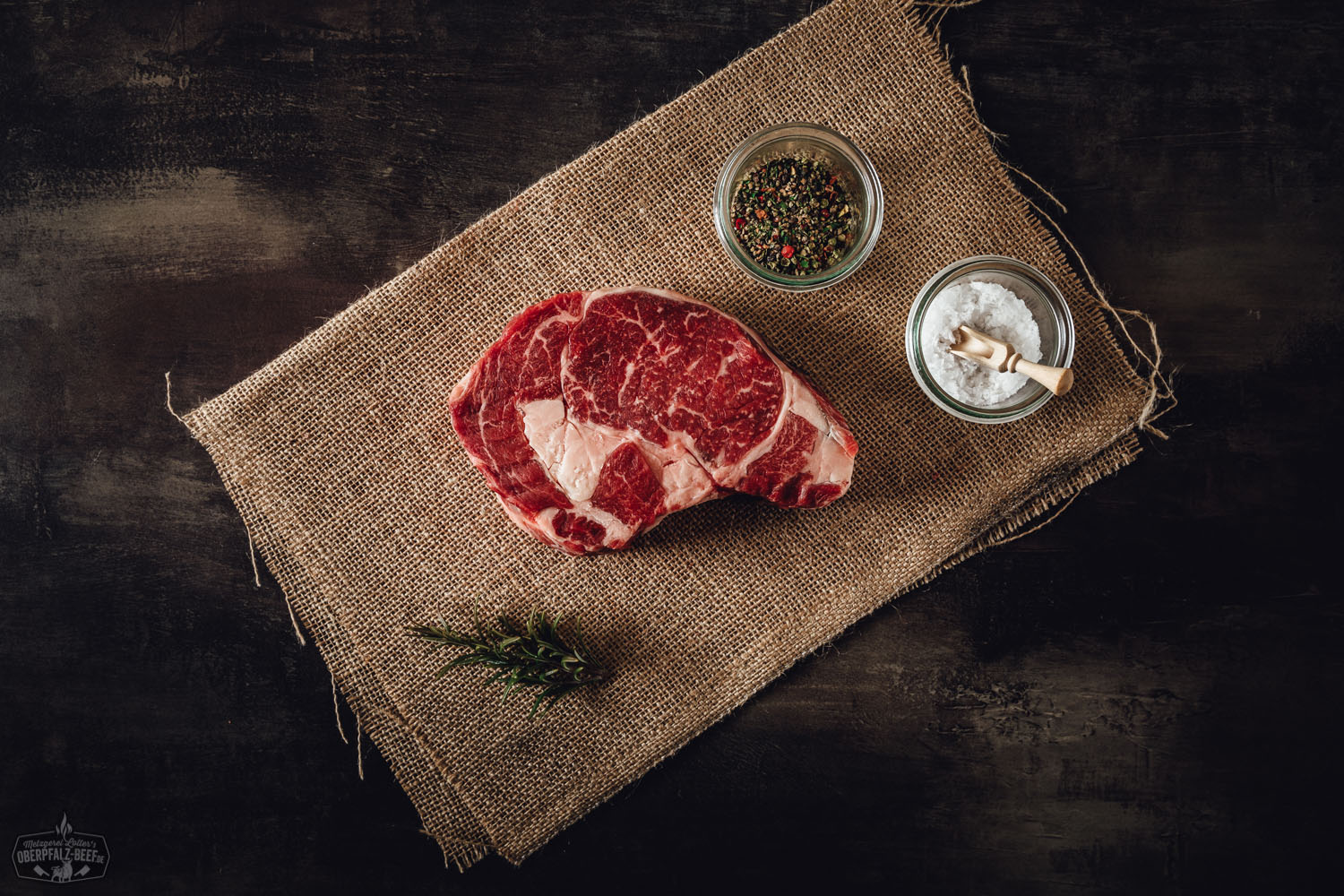 Dry-Aged Entrecote Rib-Eye Steak vom Oberpfalz-Rind, serviert auf einem rustikalen Holzbrett, zeigt saftige Marmorierung und intensive Reifung, ideal für Grill- und Gourmet-Liebhaber.