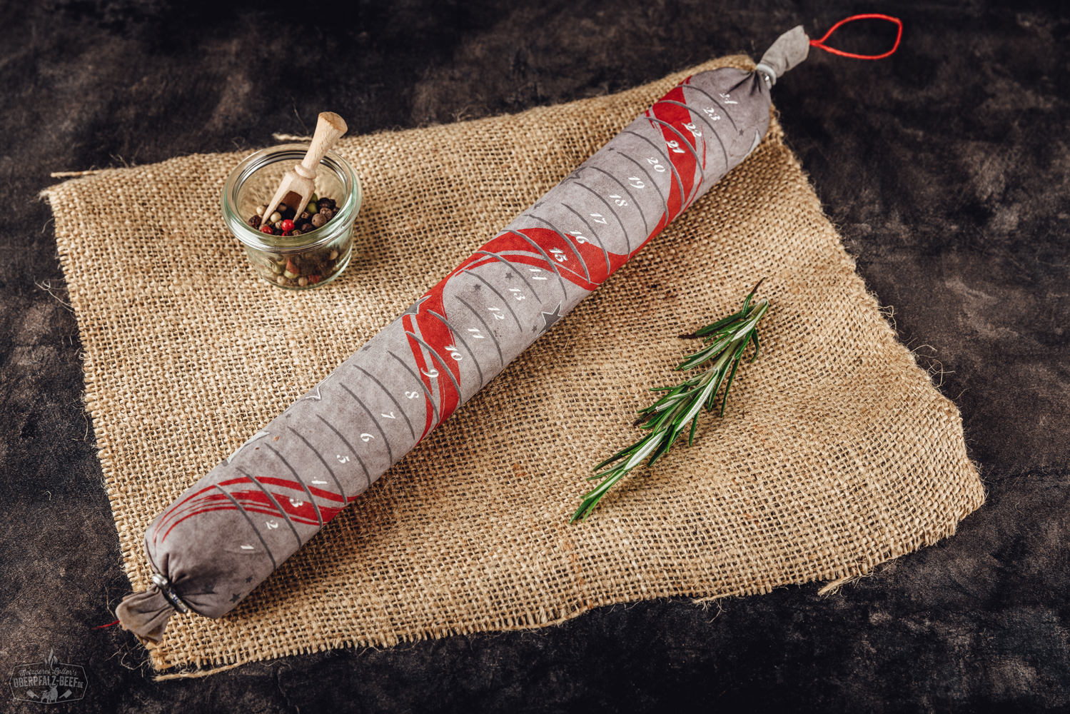 Bild eines Adventskalenders mit 24 Scheiben Salami, präsentiert auf einer Holzoberfläche, ideal für Fleischliebhaber während der Weihnachtszeit.