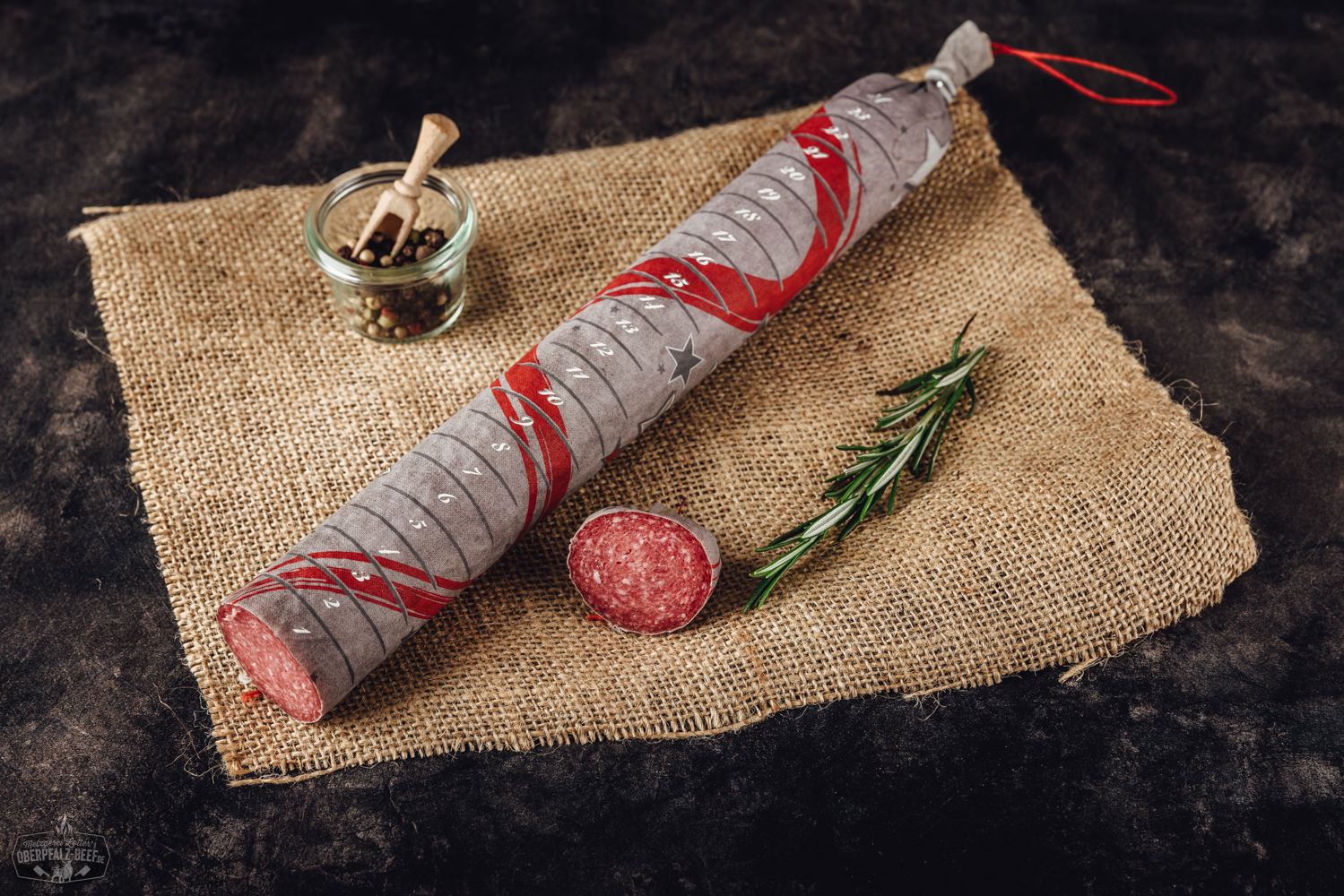 Bild eines Adventskalenders mit 24 Scheiben Salami, präsentiert auf einer Holzoberfläche, ideal für Fleischliebhaber während der Weihnachtszeit.