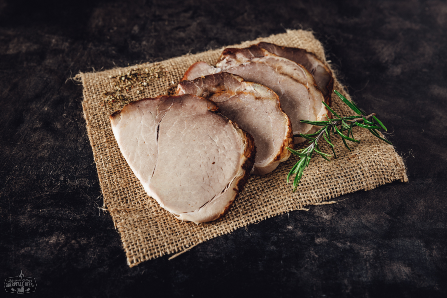 Sous Vide vorgegarter Schweinebraten auf einem Teller serviert, mit goldbrauner Kruste und saftigem Fleisch, begleitet von Kräutergarnitur. Perfekt für Feinschmecker und Liebhaber der gehobenen Küche.