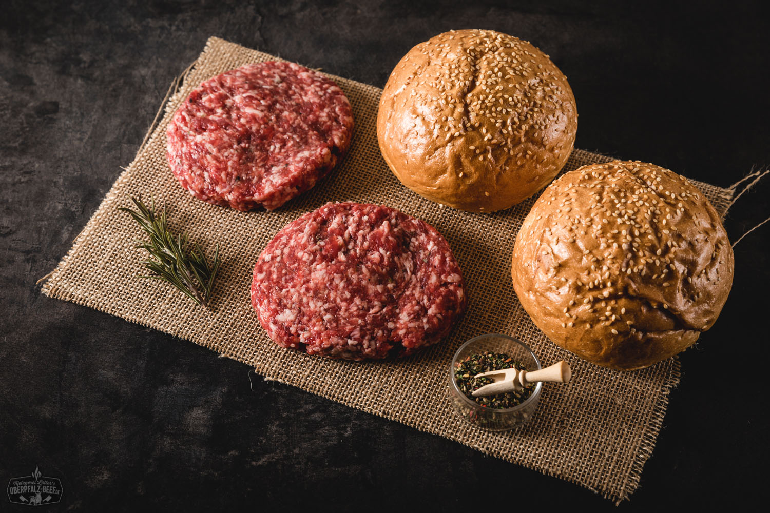 Abbildung eines Burger-Pakets aus Wildfleisch, bestehend aus frischen Wildfleisch-Patties, auf einer rustikalen Holztischplatte drapiert - Premiumqualität von Oberpfalz Beef für ein unvergleichliches Geschmackserlebnis.