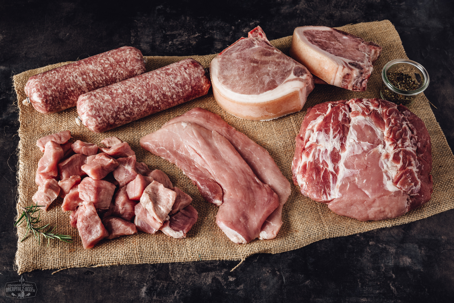 Ein Bild einer Bauernhof-Box, gefüllt mit hochwertigem Schweinefleisch aus der Oberpfalz, präsentiert verpackte Fleischstücke in nachhaltigen Materialien auf einem rustikalen Holztisch.