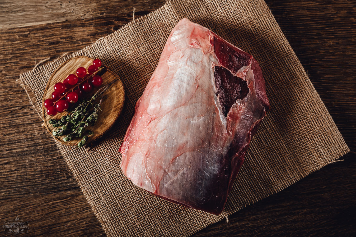 Bild eines hochwertigen Rückenstücks ohne Knochen vom Oberpfälzer Hirschfleisch, präsentiert auf einem rustikalen Holzbrett, ideal für feine Wildgerichte.