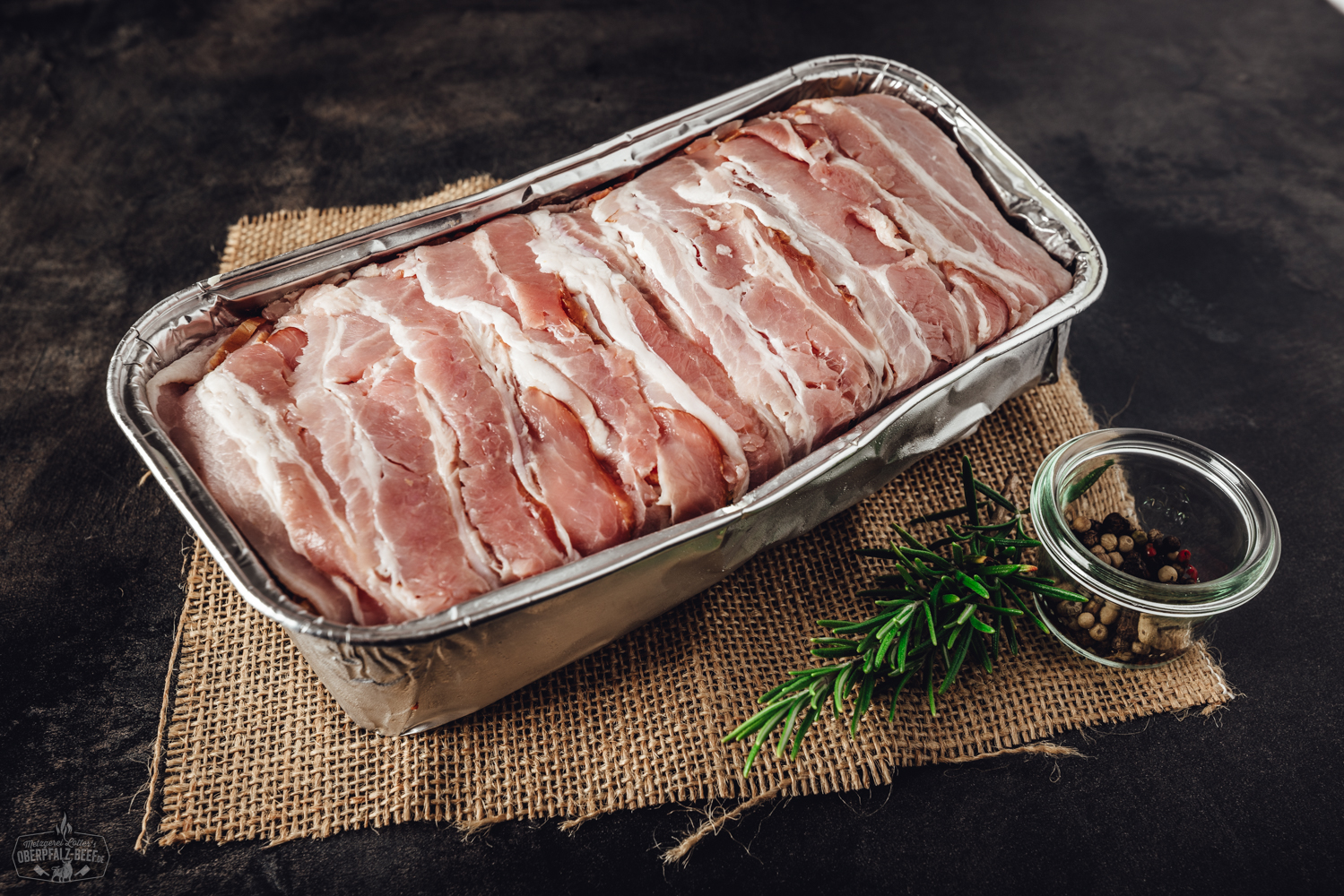 Ein herzhaft gefüllter Hackbraten namens Bacon Bomb mit knusprigem Speck umwickelt, perfekt gegrillt für einen saftigen BBQ-Genuss.